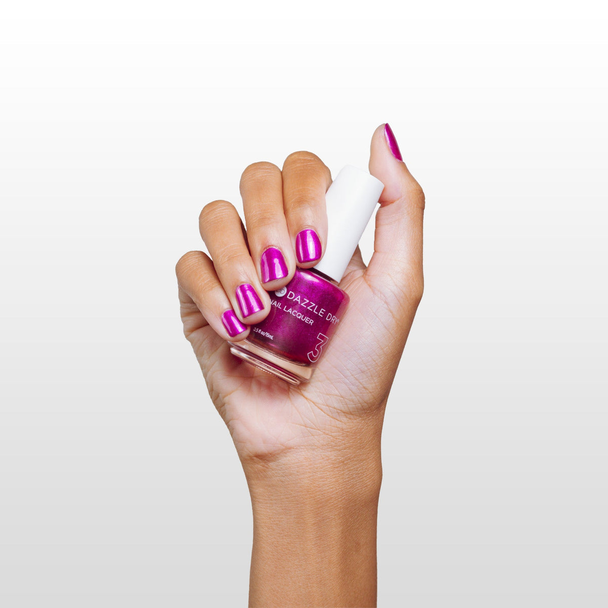 Hand with Kaleidoscope painted on nails holding lacquer bottle