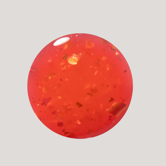 Red translucent sphere with specks on a gray background