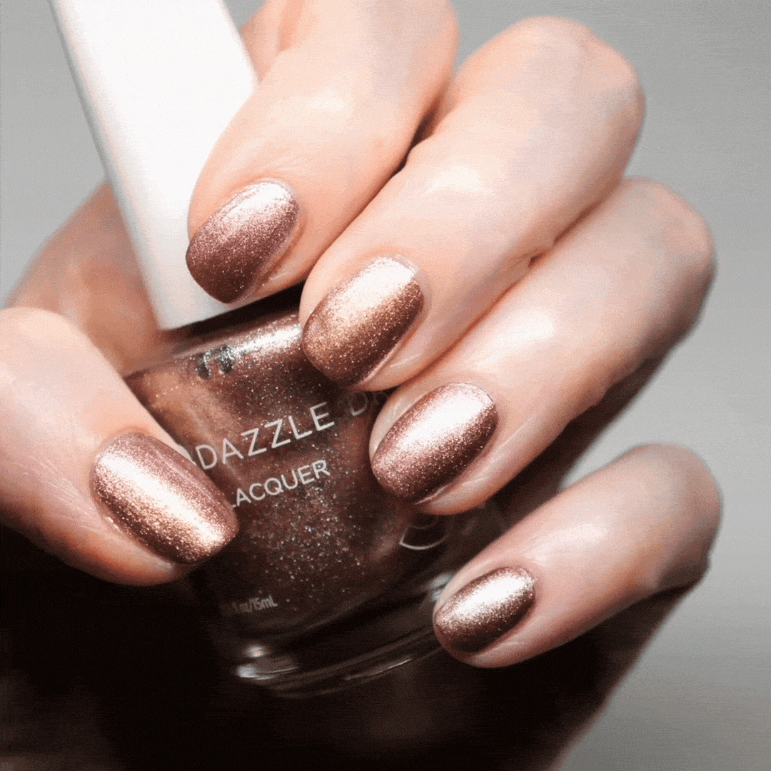 Hand with Out N' About painted on nails holding lacquer bottle