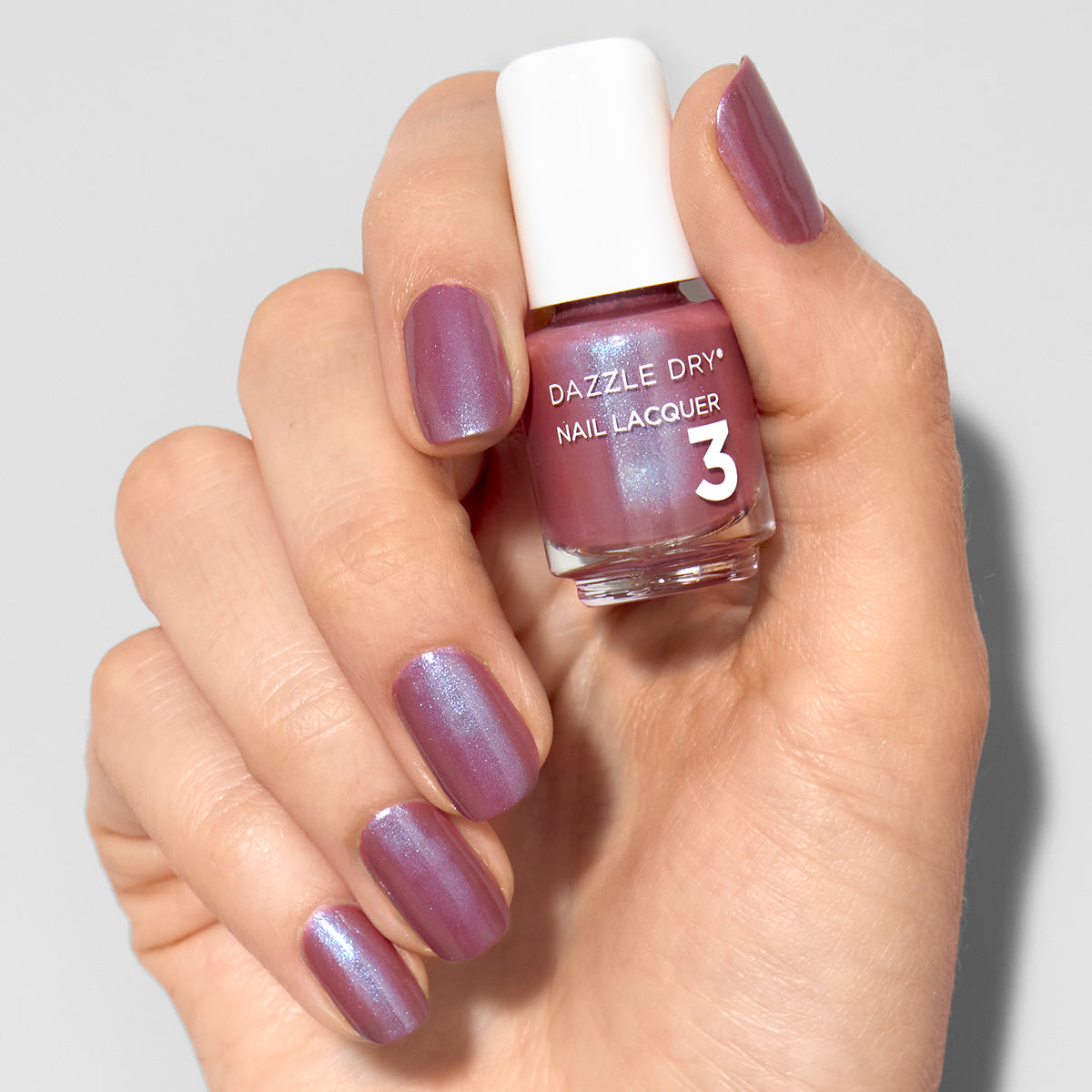 Hand with School Spirit painted on nails holding mini lacquer bottle