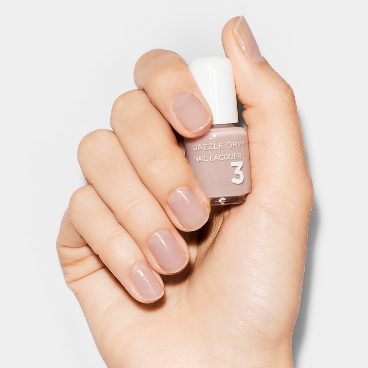 Hand with Chiffon Moment painted on nails holding mini nail lacquer bottle