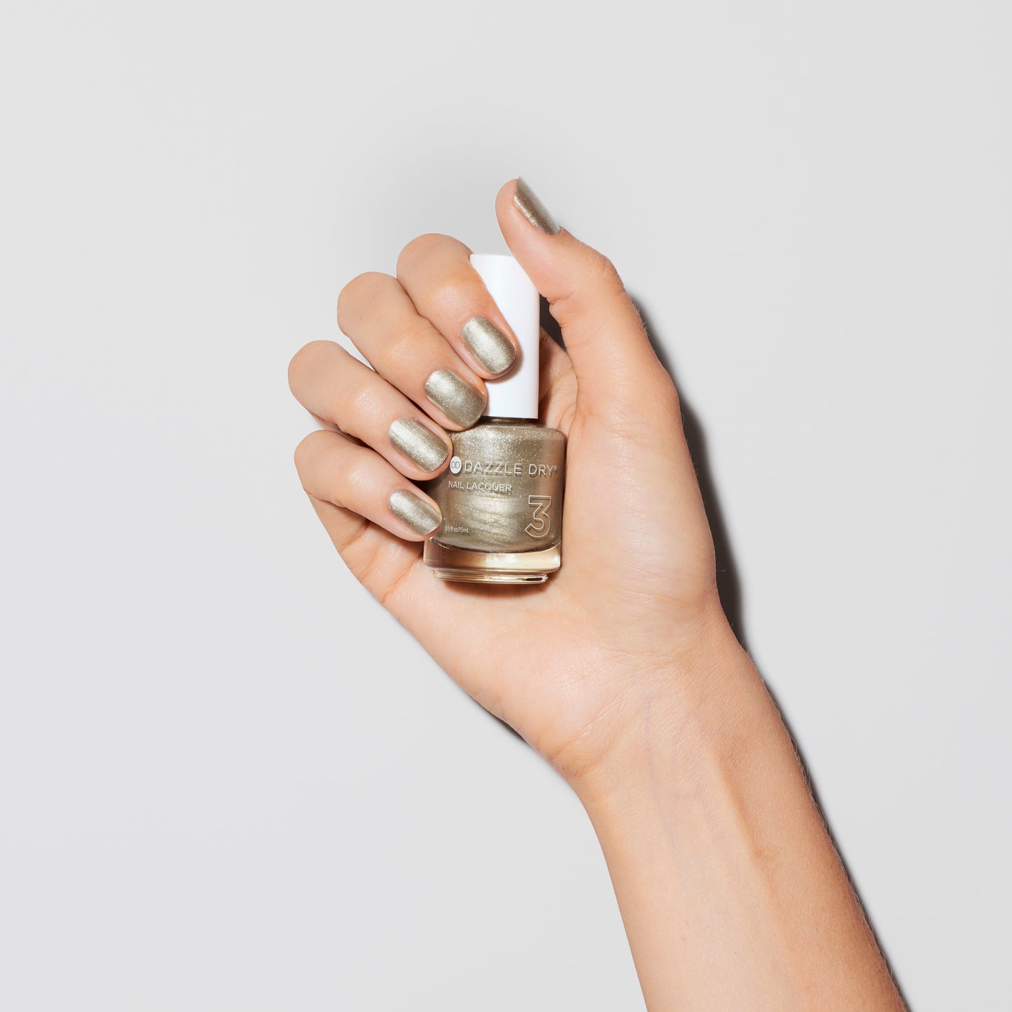 Hand with Illuminate painted on nails holding nail lacquer bottle