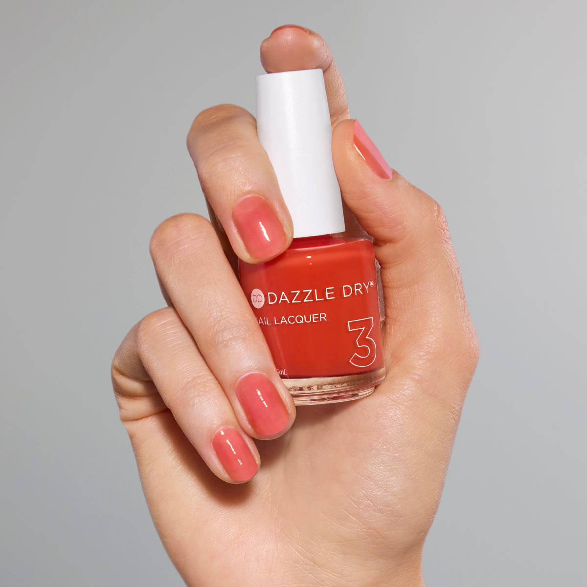Hand with Sweet and Juicy painted on nails holding full size lacquer bottle