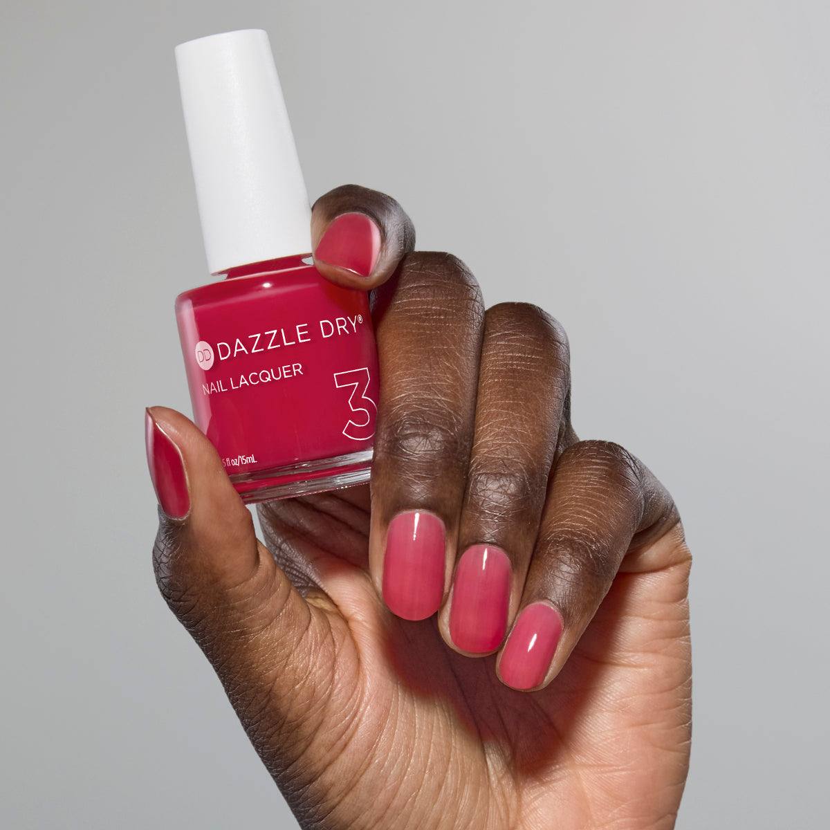 Hand with Sugar Dipped painted on nails holding lacquer bottle