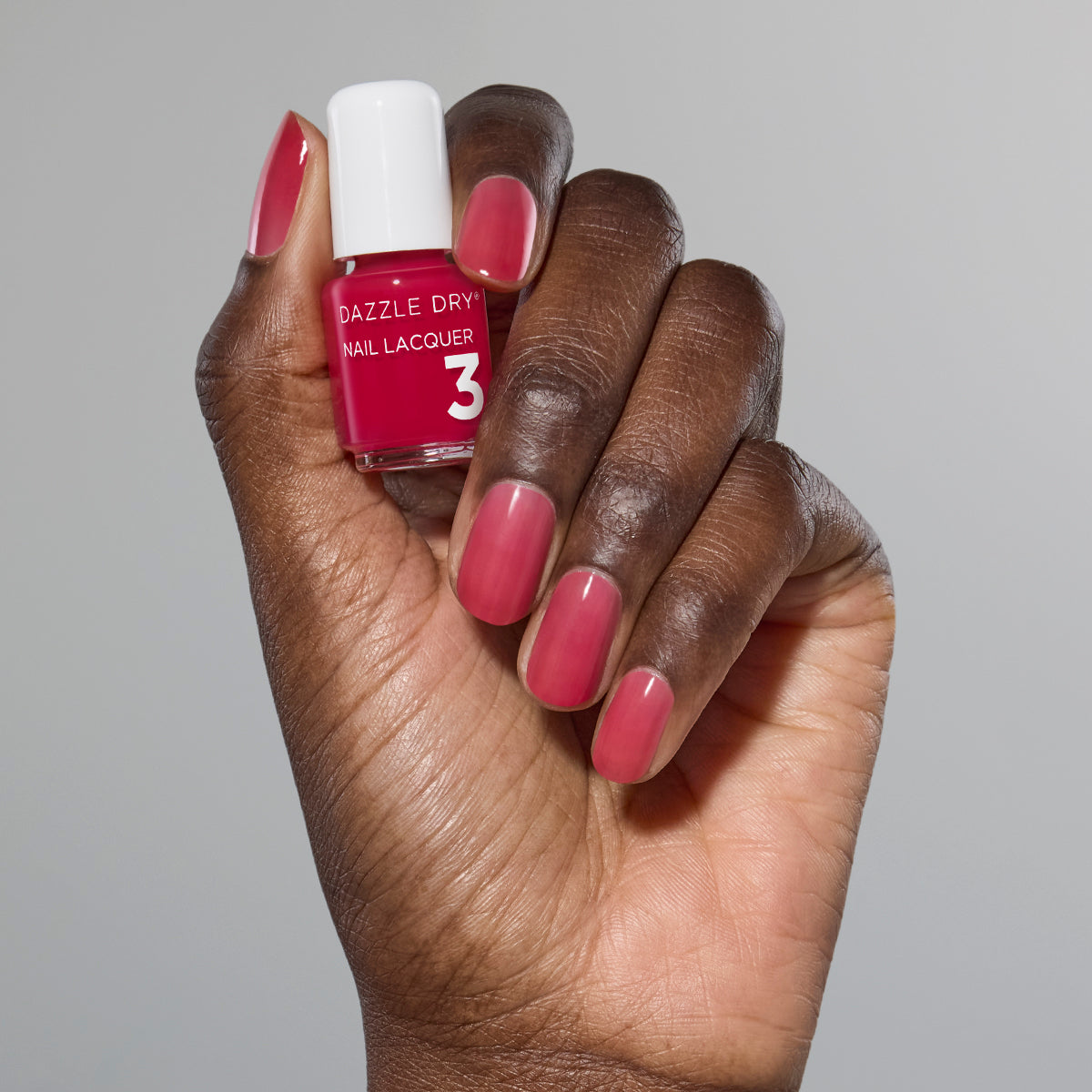 Hand with Sugar Dipped painted on nails holding mini lacquer bottle