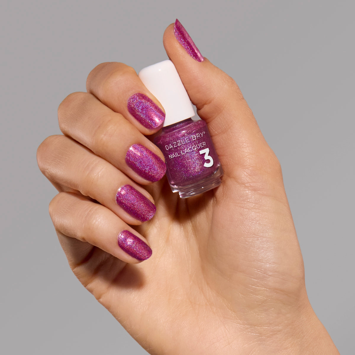 Hand with Beauty Sleep painted on fingernails holding mini nail polish bottle