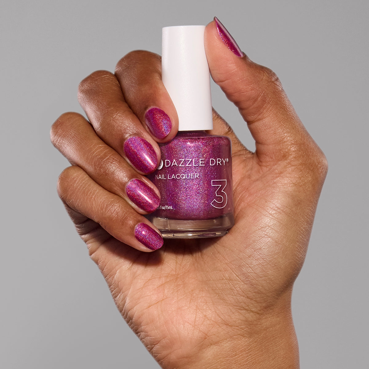Hand with Beauty Sleep painted on nails holding lacquer bottle