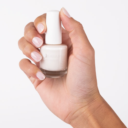 Hand with Breathe Free painted on nails holding lacquer bottle