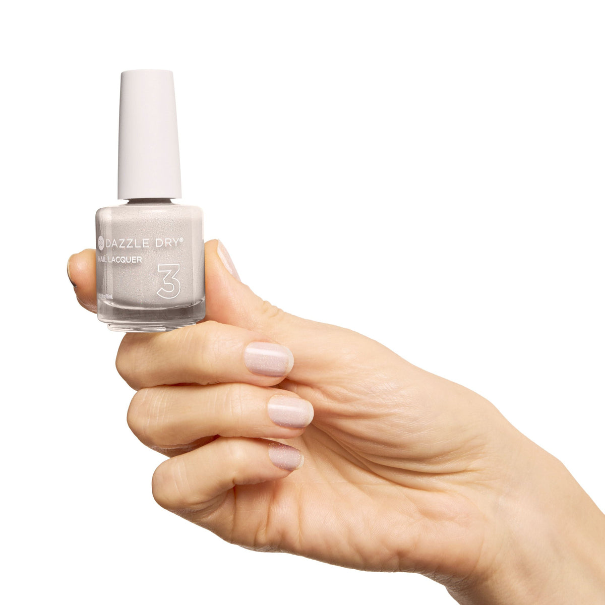 A hand holding a bottle of nail polish against a solid white background. The nail polish is a very pale, cool-toned grayish pink, and the bottle has a white cap.