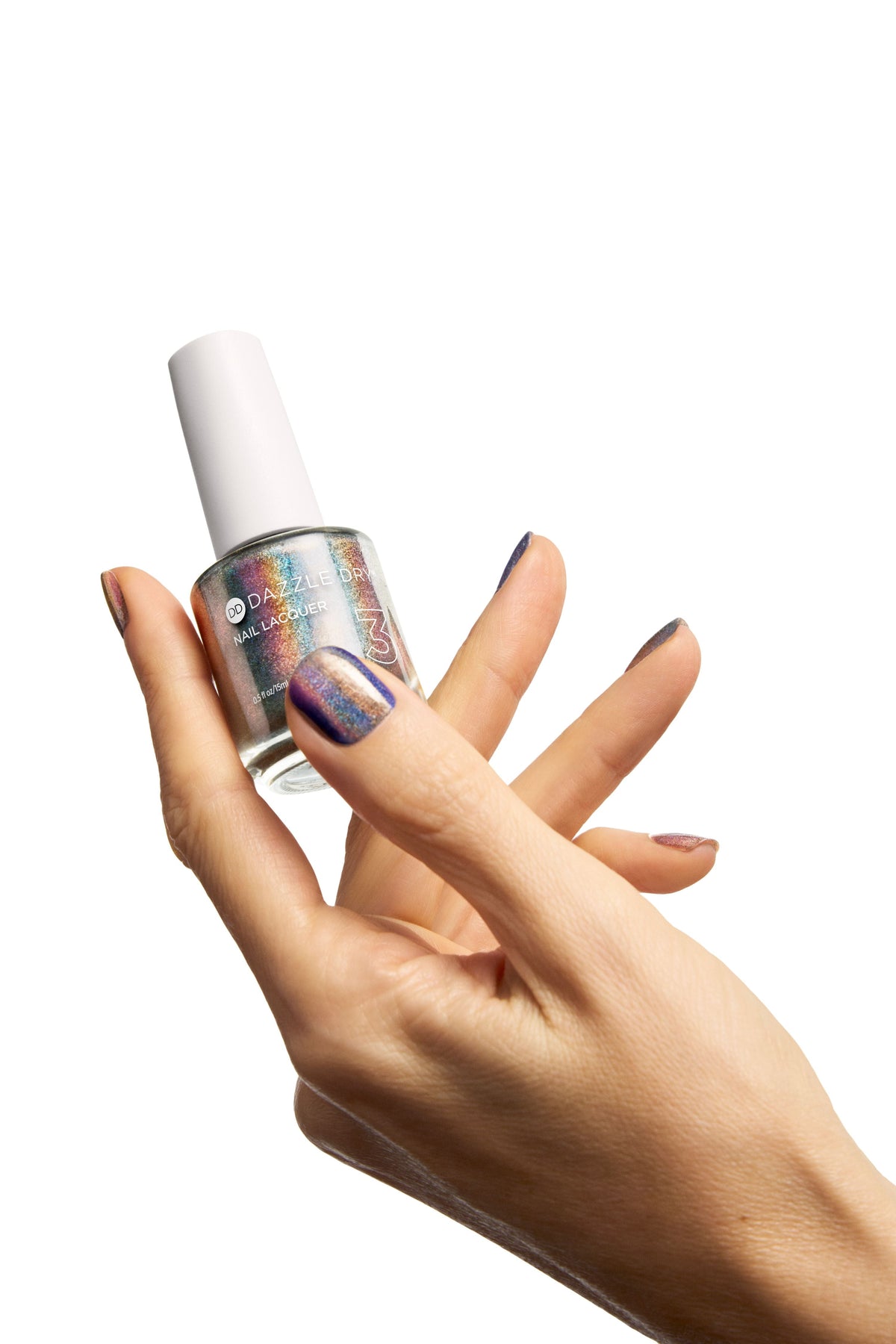 A hand holding a bottle of Multichrome nail polish, showcasing the iridescent holographic polish on the fingernails against a solid white background.