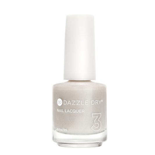 A bottle of Dazzle Dry Nail Lacquer in shade 3, featuring a shimmering light champagne-beige color and a white cap, set against a plain white background.