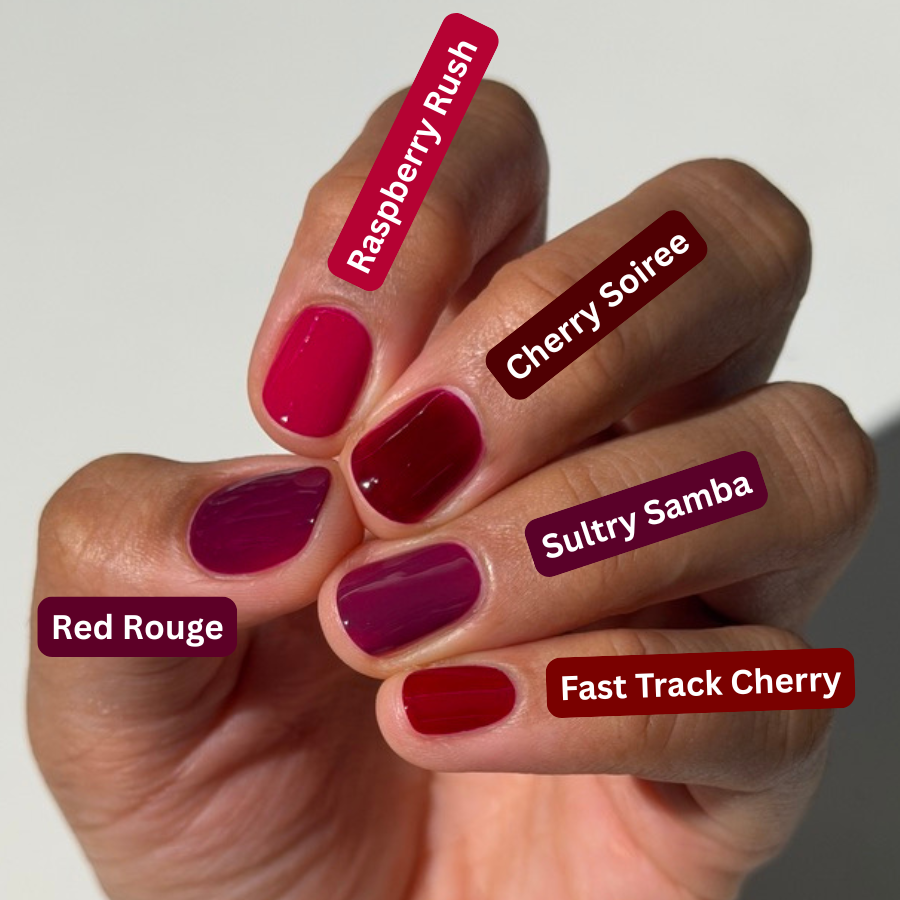 A hand with six different nail polish colors shown, each labeled with a shade name: Raspberry Rush, Cherry Soifee, Sultry Samba, Red Rouge, and Fast Track Cherry. The nails are painted in glossy shades of pink, burgundy, and deep plum against a plain light background.