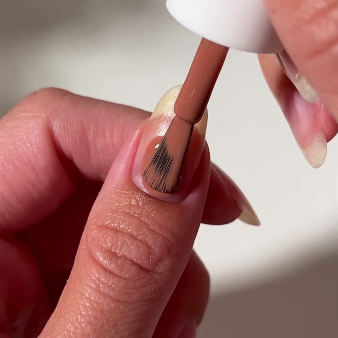 video of brown nail polish painted onto nail