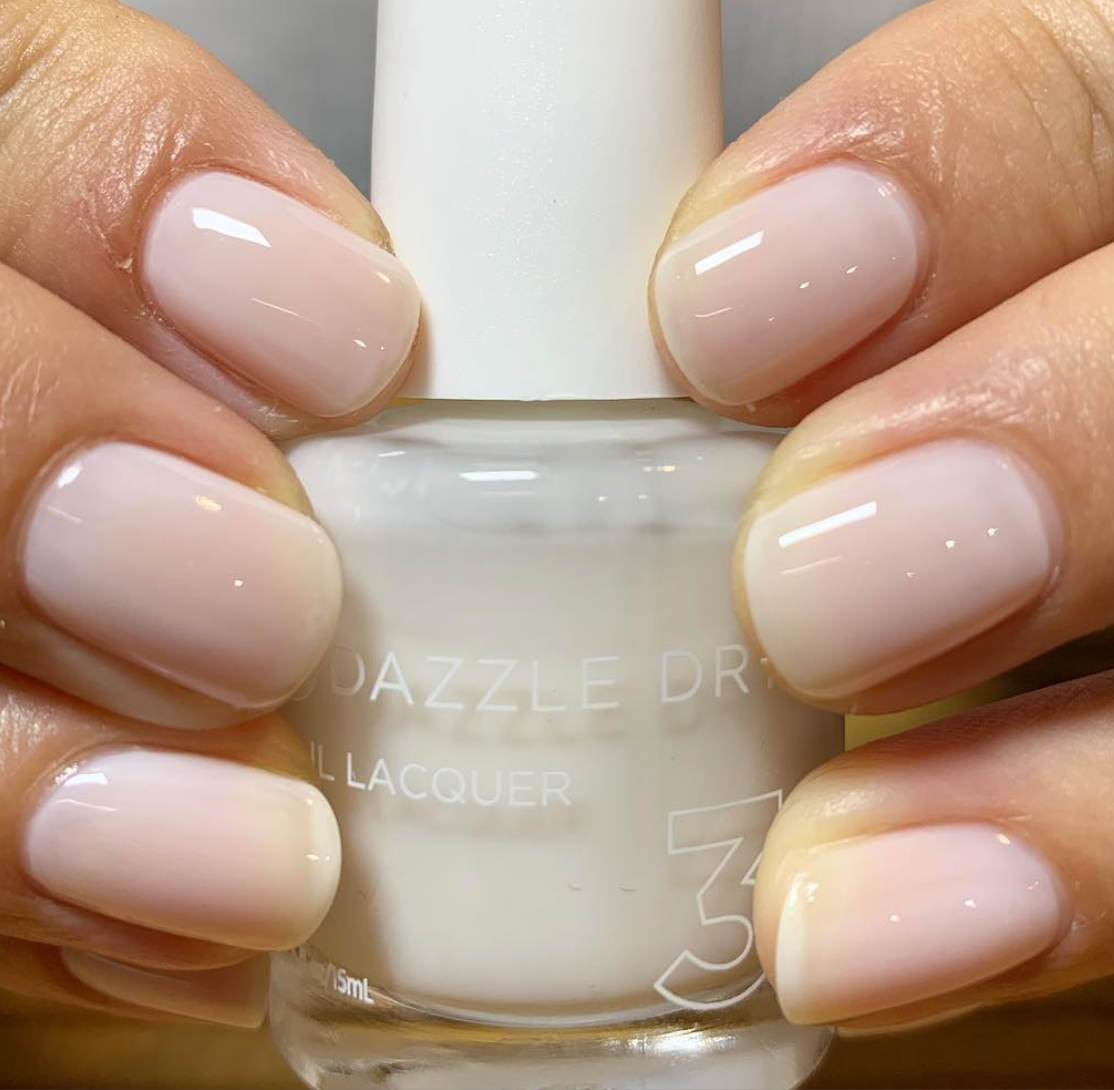 Hands with Fine China painted on nails holding lacquer bottle